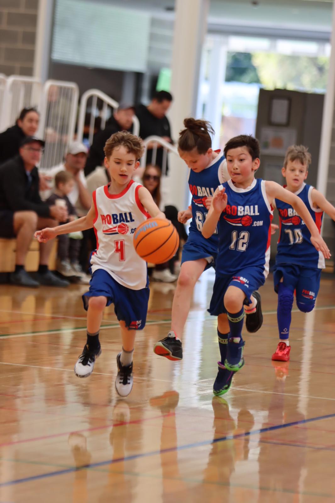 ProBall U10 Blazers and Hornets basketball players competing against older U12 teams in Sydney, showing how challenging young athletes can support their development, resilience and confidence.